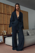 Woman wearing Olive Muse linen two-piece set with V-neck top and wide-leg pants, front view
