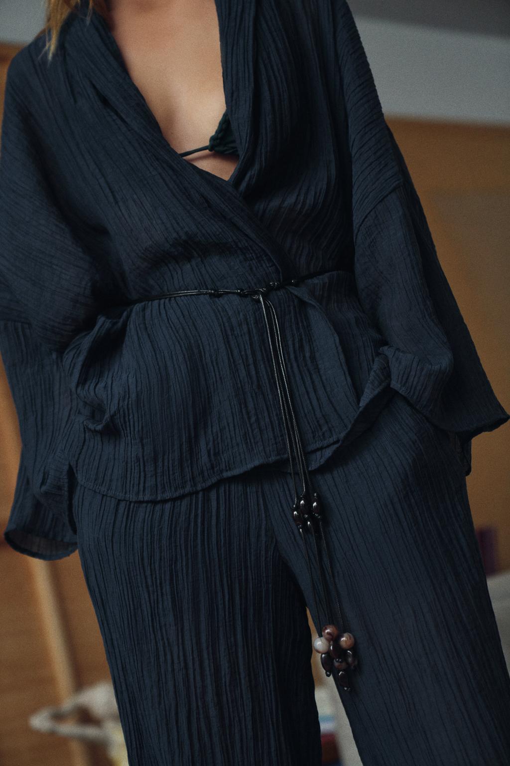 Woman wearing Olive Muse linen co-ord set, side view showing wide-leg pants fit